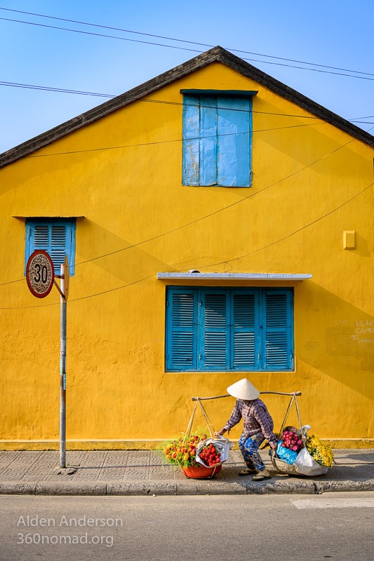 Hoa carries flowers to sell at the market in Hoi An, Vietnam